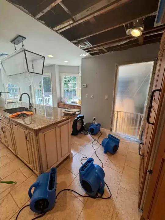 Air movers running across a kitchen floor after a water leak