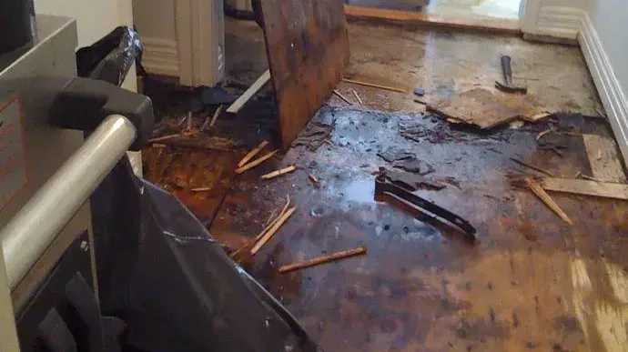 Wet subfloor showing where water-soaked flooring was torn out