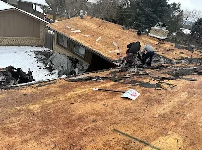 A storm-damaged roof stripped open down to the wood decking